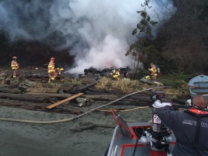 NKF&R firefighters use hoses deployed from the district’s new fire-rescue boat and water from Hood Canal to battle a fire in a cabin that had no usable road access or fire hydrants nearby. 